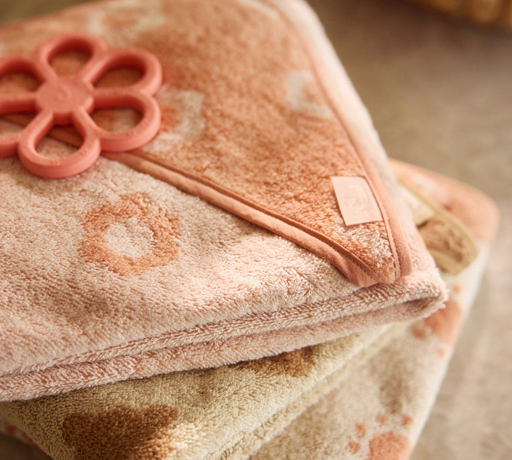 Close-up of the Jollein Coral Rose flower silicone teething ring on pink fabric
