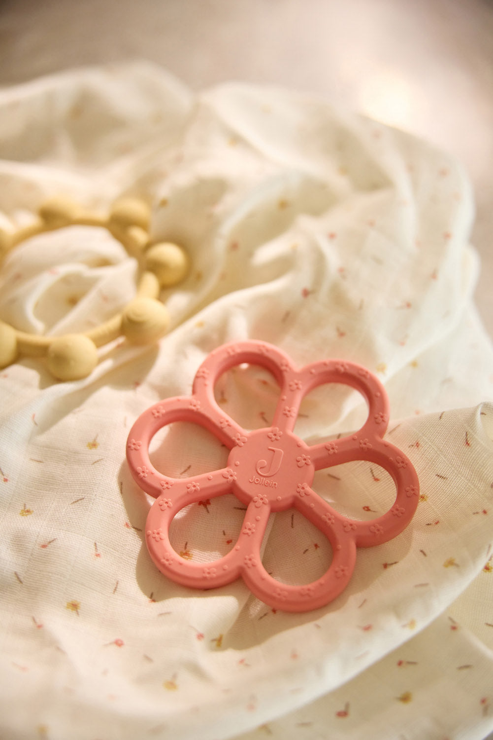 Close-up of the Jollein flower and sun silicone teething rings in Coral Rose and Vanilla