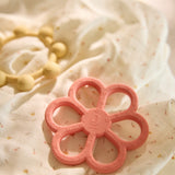 Close-up of the Jollein flower and sun silicone teething rings in Coral Rose and Vanilla