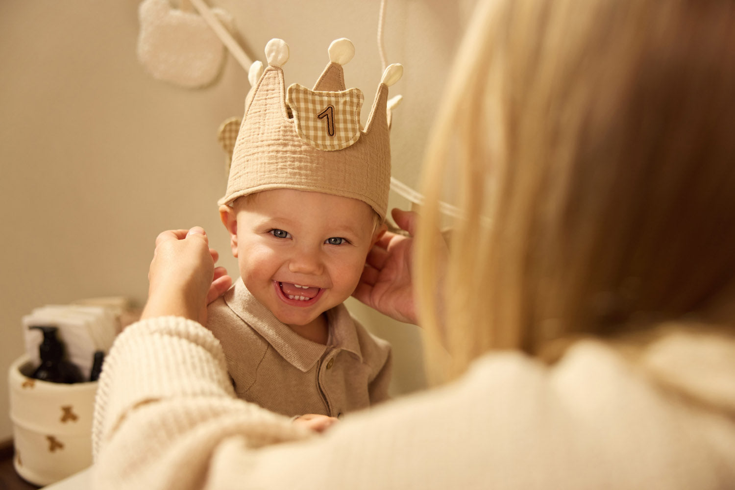 Child wearing the Jollein Teddy Bear birthday crown with number 1 while an adult adjusts it