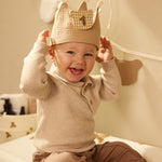 Child wearing a Jollein Teddy Bear birthday crown with number 1 while seated on a Teddy Bear changing-pad cover