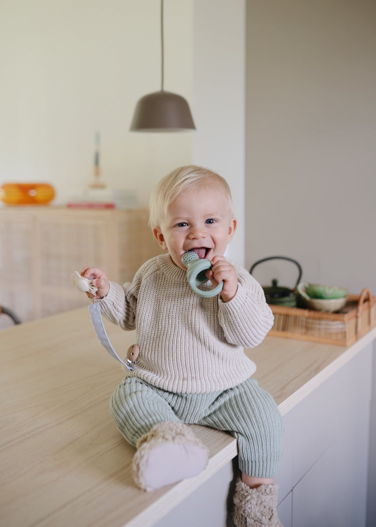 Toddler with the Mushie Silicone Fresh Food Feeder (2pack) Sage