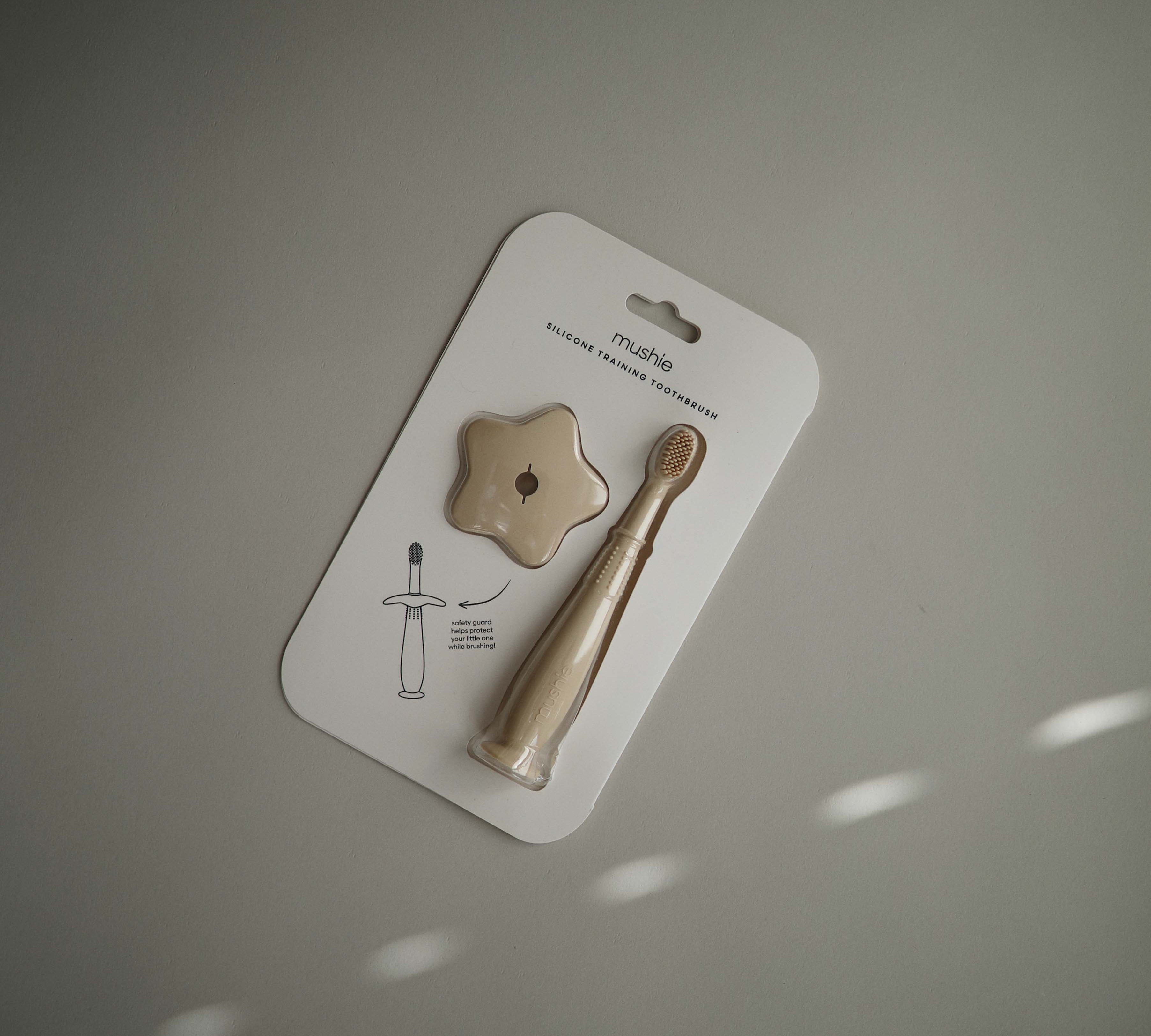 Mushie flower training toothbrush shifting sand