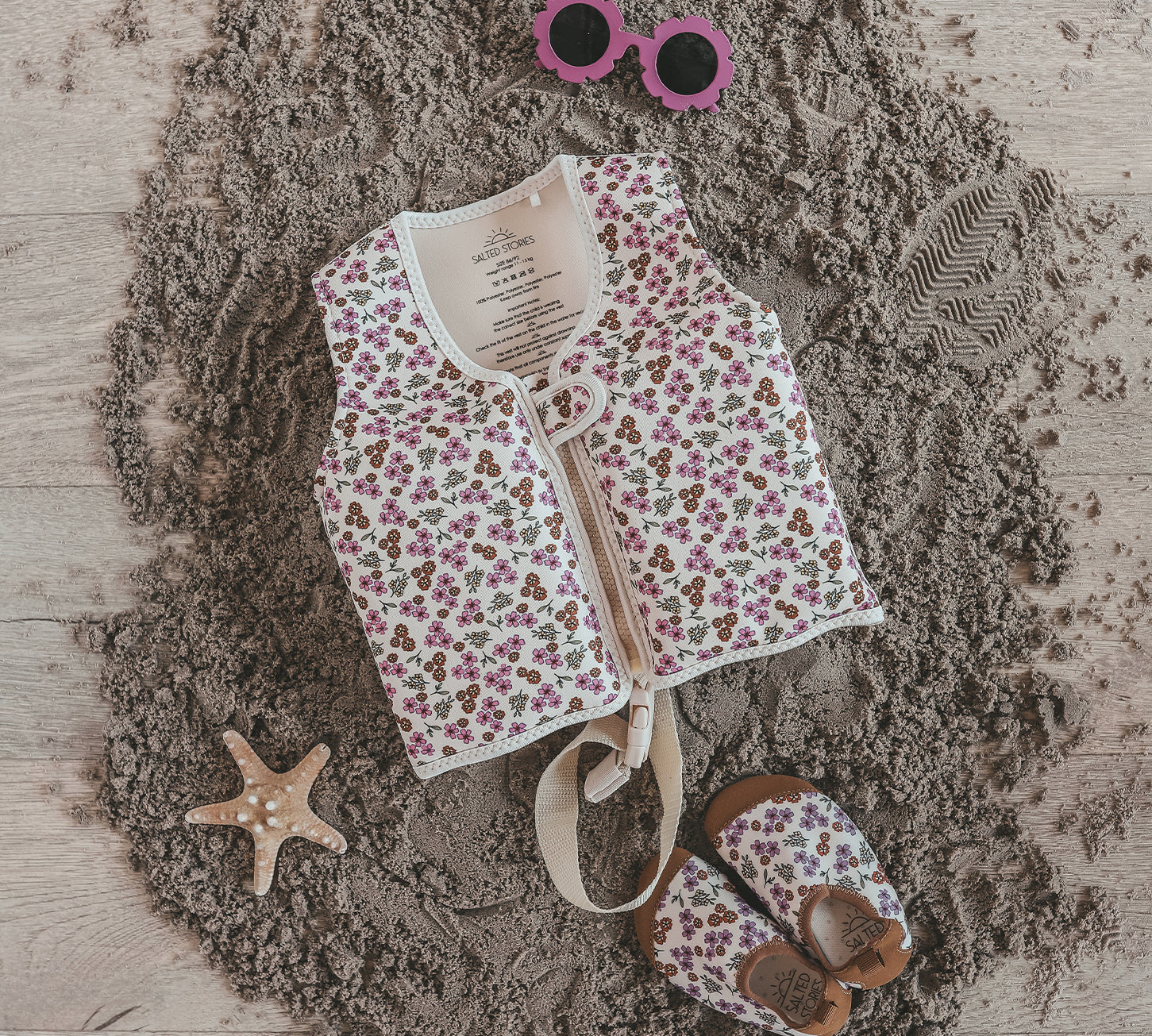 Child wearing Salted Stories Sparkly Flowers floating vest in White Swan