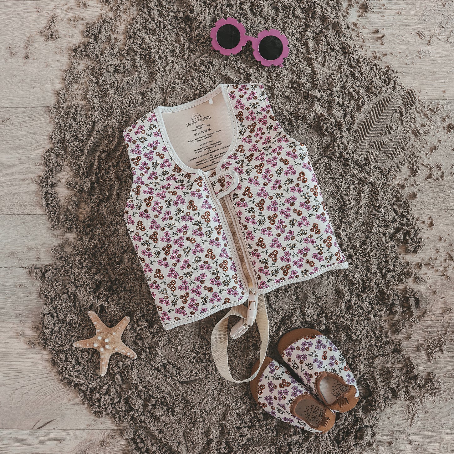 Child wearing Salted Stories Sparkly Flowers floating vest in White Swan