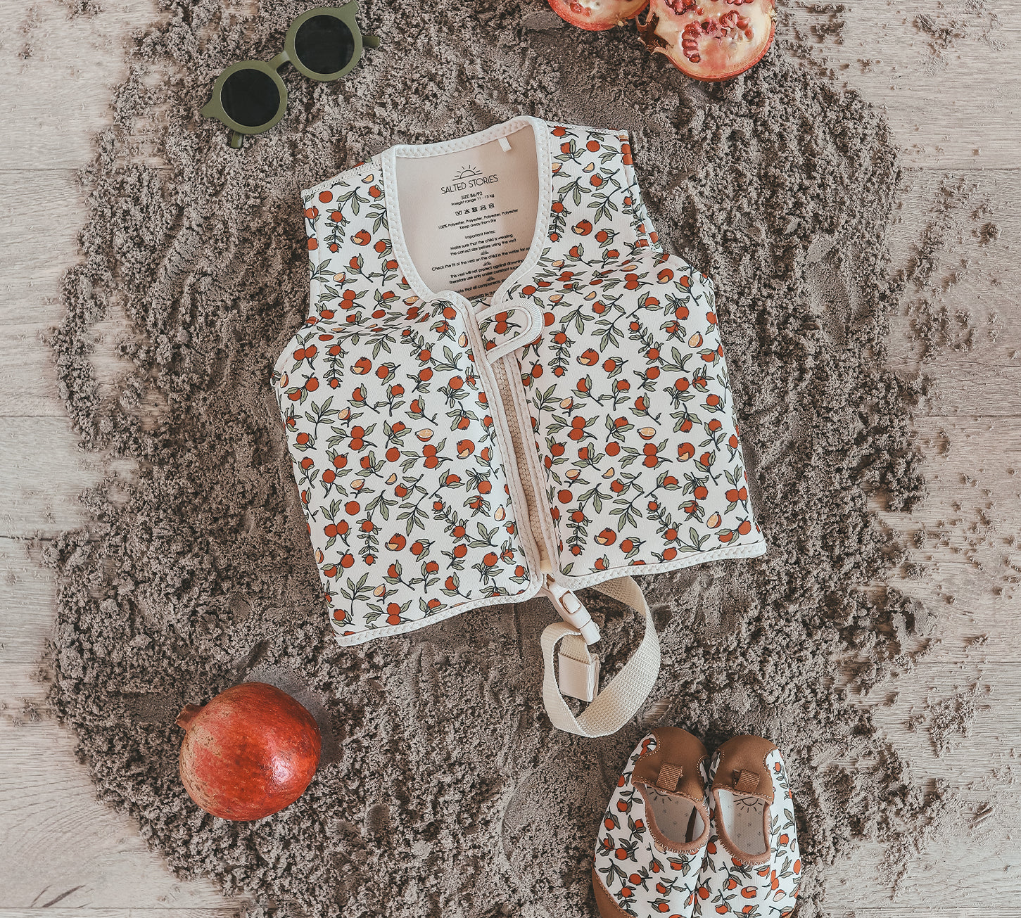 Child wearing Salted Stories Pomegranate floating vest in White Swan