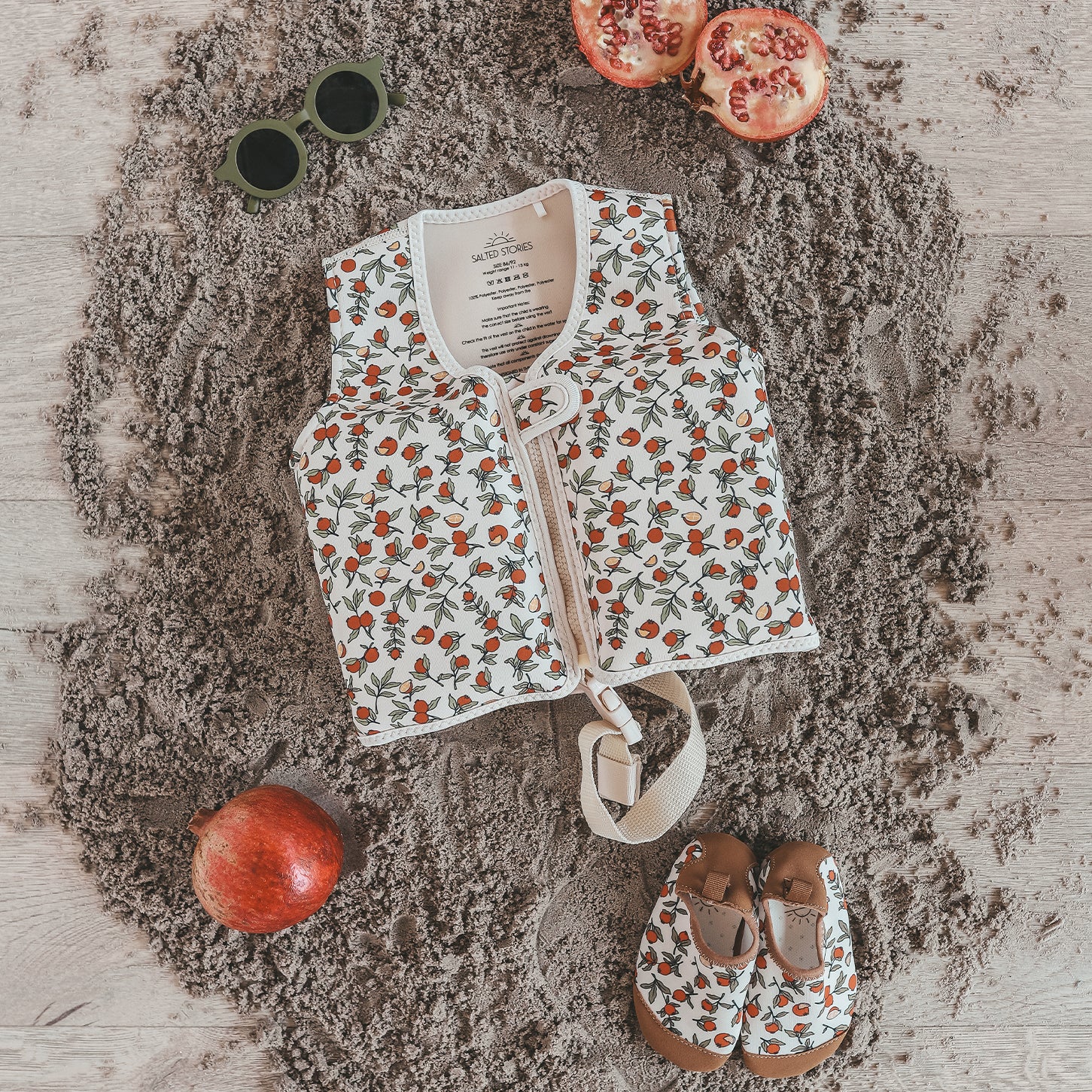 Child wearing Salted Stories Pomegranate floating vest in White Swan