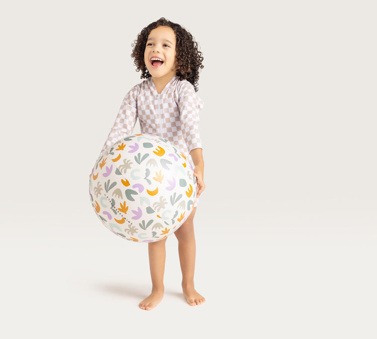 Kid wearing Swim Essentials Baby Swim Suit Sand Check and holding a ball